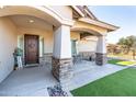 Inviting covered porch with stone pillars, a stylish front door, and an outdoor seating area at 18637 E Flintlock Dr, Queen Creek, AZ 85142