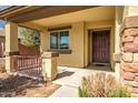 Inviting covered front porch showcasing stone accents and a decorative front door at 18648 W Lupine Ave, Goodyear, AZ 85338