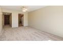 Open-concept living room with neutral carpet and ceiling fan, flowing into the kitchen at 2104 W Yukon Dr, Phoenix, AZ 85027