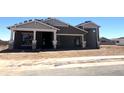 Charming home under construction with a neutral color scheme and spacious garage, set against a clear blue sky at 22961 E Twin Acres Dr, Queen Creek, AZ 85142