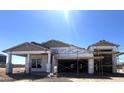 Unfinished exterior of a home with a two-car garage under construction on a sunny day at 22961 E Twin Acres Dr, Queen Creek, AZ 85142