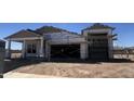 Unfinished home with a two-car garage and a covered porch framed by columns under a clear, sunny sky at 22961 E Twin Acres Dr, Queen Creek, AZ 85142