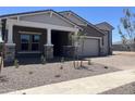 Beautiful home showcasing a covered front porch, well-kept landscaping, and a two-car garage at 22961 E Twin Acres Dr, Queen Creek, AZ 85142