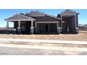 New home under construction featuring a spacious three car garage with open doorways and a desert-style landscape at 22961 E Twin Acres Dr, Queen Creek, AZ 85142