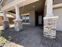 Inviting front porch with stone-accented columns and pavers for a touch of elegant curb appeal at 22961 E Twin Acres Dr, Queen Creek, AZ 85142