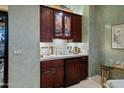 Elegant wet bar with a sink and mirrored shelves, perfect for entertaining guests at 41711 N Pinion Hills Ct, Anthem, AZ 85086