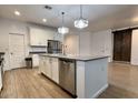 Spacious kitchen featuring a center island with a stainless steel dishwasher and a decorative barn door at 559 W Magena Dr, San Tan Valley, AZ 85140