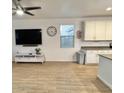 Open-concept space with modern flooring, ceiling fan, mounted television, and adjacent kitchen at 559 W Magena Dr, San Tan Valley, AZ 85140