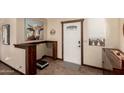 Bright foyer featuring tile flooring, a decorative front door, and custom woodworking details at 8118 E Medina Ave, Mesa, AZ 85209