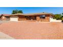 Traditional single-story brick home with an attached two-car garage and xeriscaped front yard for low maintenance at 8118 E Medina Ave, Mesa, AZ 85209