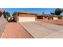 Charming single-story brick home featuring an attached two-car garage and a low maintenance front yard at 8118 E Medina Ave, Mesa, AZ 85209
