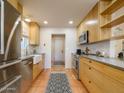 Well-lit kitchen featuring custom wood cabinetry, modern appliances, and a view of the entryway at 8720 E Via De Dorado --, Scottsdale, AZ 85258