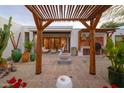 Beautifully designed outdoor patio area with pergola, fire pit, grill, and lush plantings at 8720 E Via De Dorado --, Scottsdale, AZ 85258
