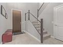 Inviting foyer features tile flooring, contemporary staircase, and a modern front door at 10054 E Bell Rd, Scottsdale, AZ 85260