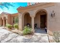 Covered front porch features neutral paint, desert landscaping, and charming details at 10054 E Bell Rd, Scottsdale, AZ 85260