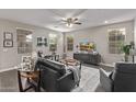 Open-concept living room with dark wood floors, neutral walls, and large windows at 10054 E Bell Rd, Scottsdale, AZ 85260