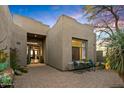 Inviting front entrance featuring a desert-themed courtyard with lush landscaping and a seating area at 10767 E Santa Fe Trl, Scottsdale, AZ 85262