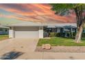 Charming single-story home featuring an attached two-car garage, rock landscaping, and wrought iron gate at 12706 W Shadow Hills Dr, Sun City West, AZ 85375