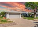 Single-story home with two-car garage, well-manicured lawn, and mature landscaping at 12706 W Shadow Hills Dr, Sun City West, AZ 85375