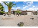 A beautiful home featuring desert landscaping with palms and a stone facade at 15542 W Cypress Point Dr, Surprise, AZ 85374