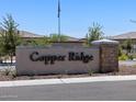 Copper Ridge community entrance sign, a welcoming landmark for residents and visitors alike at 20795 N Roadrunner Ln, Maricopa, AZ 85138