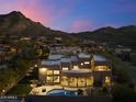 Twilight aerial view of the house showcasing the pool, outdoor seating, and surrounding desert landscape at 24019 N 112Th Pl, Scottsdale, AZ 85255