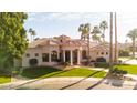 Beautifully landscaped home featuring lush greenery, a circular driveway, and elegant architectural details at 3441 S Camellia Pl, Chandler, AZ 85248