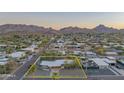 Expansive aerial view showcases the single-story home's location with mountain views and mature trees at 3531 E Onyx Ave, Phoenix, AZ 85028