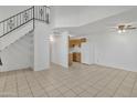 Bright living room with neutral tile floors, staircase, and open view to the kitchen at 3646 N 69Th Ave # 38, Phoenix, AZ 85033