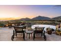 Outdoor patio with a fire pit and a luxurious inground pool overlooking the desert landscape at 40947 N 107Th Pl, Scottsdale, AZ 85262