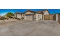 Spacious driveway leading to a two-car garage and a wooden gate, surrounded by desert landscaping at 4602 E Firestone Dr, Chandler, AZ 85249