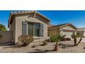 A well-kept home exterior featuring a desert landscape, blue shutters, and a two-car garage at 4602 E Firestone Dr, Chandler, AZ 85249