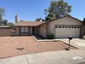 Charming home with desert landscaping, a two-car garage, and mature trees at 4927 W Golden Ln, Glendale, AZ 85302