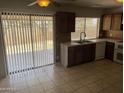 Spacious kitchen with tile flooring, dark wood cabinets, and stainless steel sink at 4927 W Golden Ln, Glendale, AZ 85302