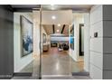 Modern home entryway featuring glass doors, concrete floors, and a glimpse of the living area at 4959 E Red Rock Dr, Phoenix, AZ 85018