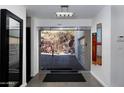 Modern home featuring a clear glass front door with a view of desert landscaping at 4959 E Red Rock Dr, Phoenix, AZ 85018