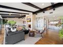 Open-concept living room with hardwood floors, a fireplace, and beamed ceilings at 4959 E Red Rock Dr, Phoenix, AZ 85018