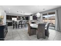 Well-lit kitchen and dining area with modern fixtures, a kitchen island and gray tile flooring at 868 W Desert Glen Dr, San Tan Valley, AZ 85143