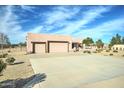 This home features a large driveway and a three-car garage, along with a desert landscape and stucco exterior at 934 E Carlise Rd, Phoenix, AZ 85086