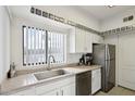 Bright kitchen with white cabinets, stainless steel appliances, and a window overlooking the outdoors at 10401 N Saguaro Blvd # 104, Fountain Hills, AZ 85268