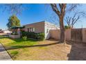 This home boasts a well-manicured lawn, mature trees, and charming curb appeal at 1051 E 8Th Ave, Mesa, AZ 85204