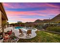 Backyard oasis featuring a pristine pool, lush landscaping, mountain views and sunset skies, perfect for relaxing at 12770 N 145Th Way, Scottsdale, AZ 85259