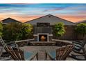 Cozy outdoor fireplace on a stone patio, perfect for entertaining in a serene backyard setting at 1319 N Chatsworth St, Mesa, AZ 85207