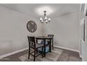 A quaint dining space highlighted by a modern chandelier and a round table with seating for two at 1340 N Recker Rd # 118, Mesa, AZ 85205