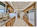 Functional kitchen with wood cabinetry, neutral countertops, and updated appliances at 13410 N Cedar Dr, Sun City, AZ 85351