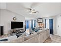 Spacious living room featuring a brick fireplace, a ceiling fan, and comfortable furniture at 15002 W Heritage Oak Way, Surprise, AZ 85374