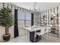 Bright dining space with modern light fixture, black and white wall paper and large window at 17742 W Brown St, Waddell, AZ 85355