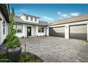 Spacious home featuring a three car garage, gray driveway pavers, and desert landscaping at 17801 W Mountainair St, Surprise, AZ 85388
