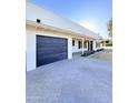 Home featuring a dark garage door and large driveway for multiple car parking at 1837 W Virginia Ave, Phoenix, AZ 85007