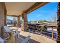 Relaxing front porch showcasing beautiful stone pillars and comfortable white Adirondack chairs at 18919 W Verde Ln, Litchfield Park, AZ 85340
